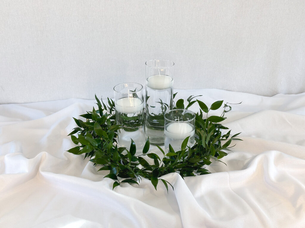 wedding centerpiece with greenery and floating candles